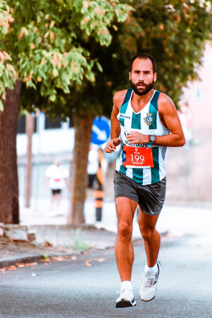 gallery-6 Male athlete running in a vibrant marathon race, showcasing focus and endurance.